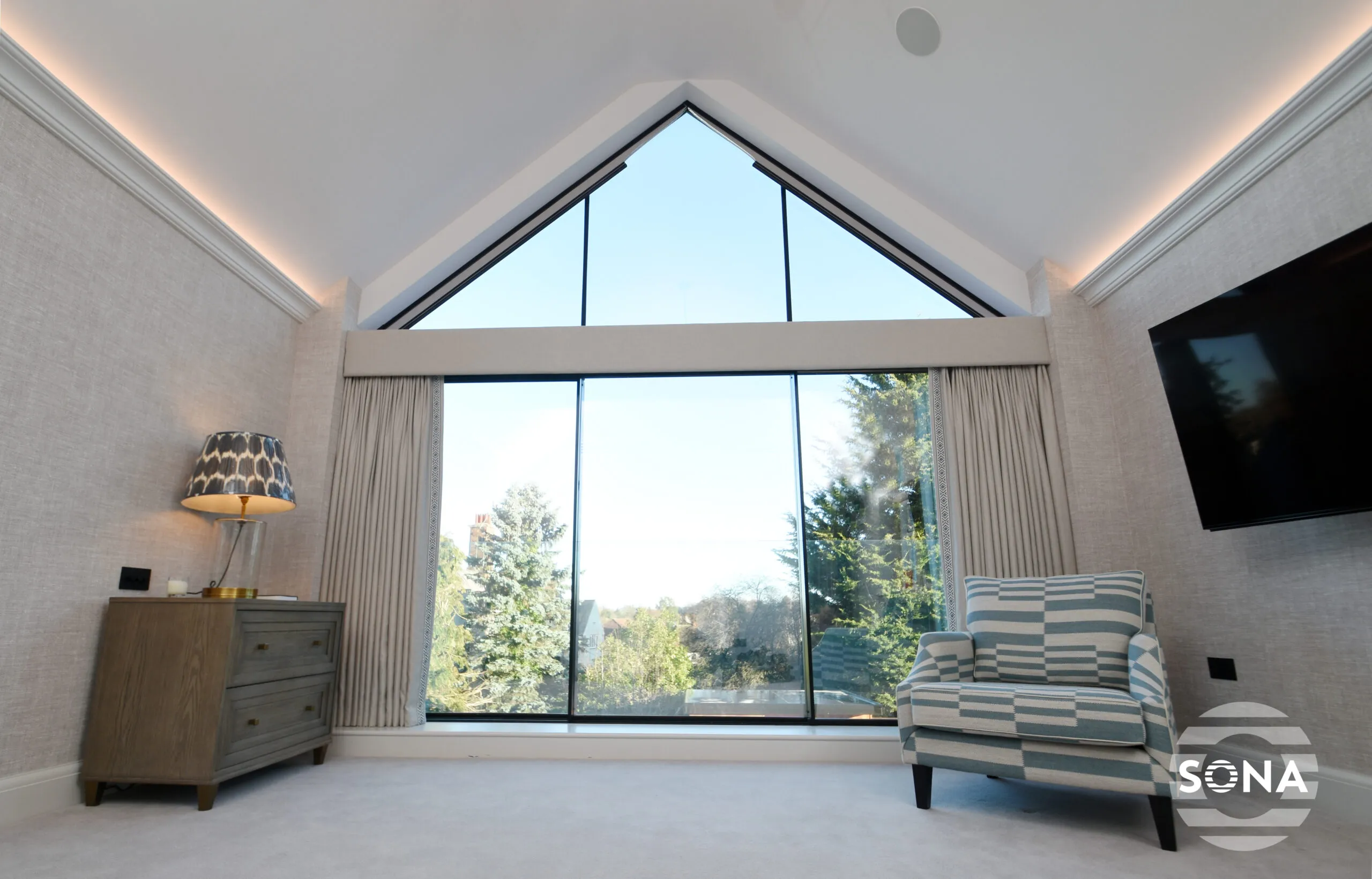 a room with a large apex window with open apex blinds. The window looks out onto a field and trees