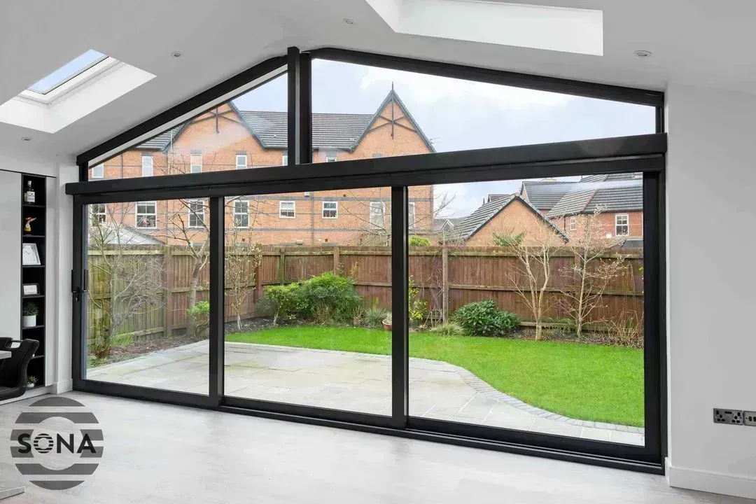 A large gable window looking out onto the garden on a bright day