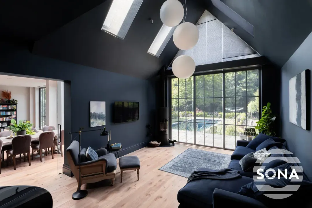 A large room with a two section window partly covered by a gable end window blind